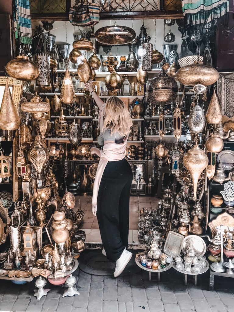 Ein Mädchen steht mit dem Rücken in einem marokkanischen Land voller Lampen.