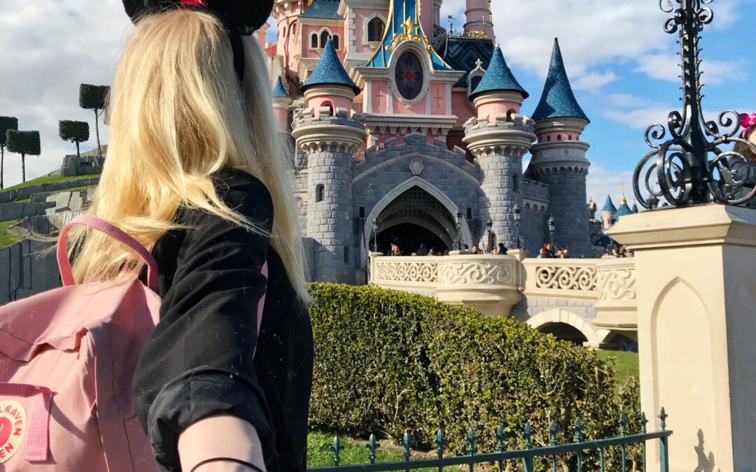 Ein Mädchen steht vor dem Schloss von Disneyland Paris