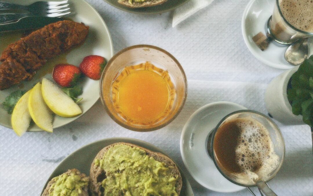 Ein Frühstückstisch mit Avocado, Kaffee und Brötchen